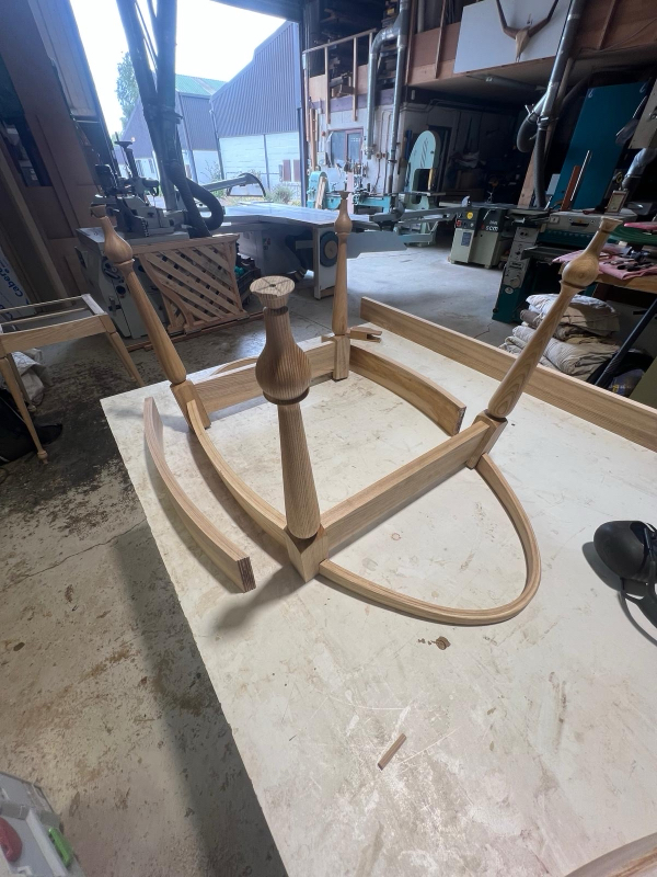 Solid timber table frame with hand-turned legs under construction in the workshop